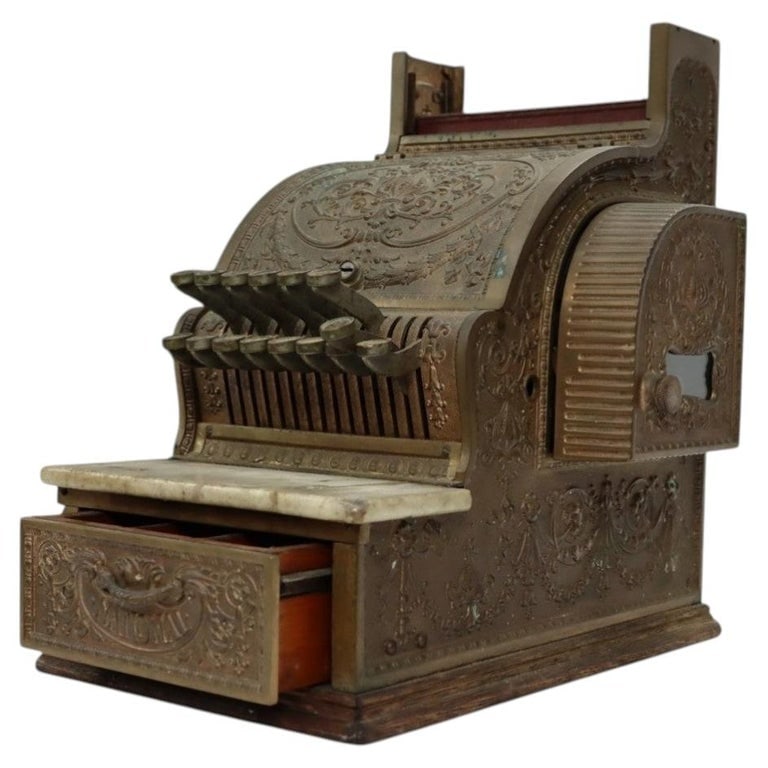 National Model 314 Brass Candy Store Cash Register C1900: An antique National Model 314 cash register, crafted from brass with an ornate, embossed design characteristic of early 20th-century commercial equipment. This piece features a marble top and a wooden