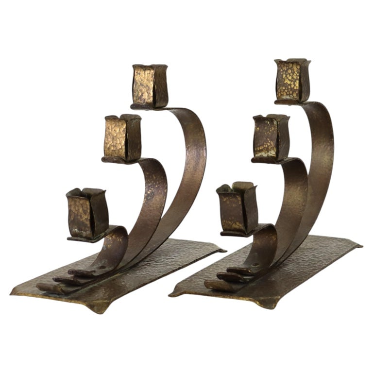 Pair E. T. C. Fish attr. Arts & Crafts Hammered Brass 3-Light Candelabra: A pair of Arts & Crafts style candelabras attributed to E. T. C. Fish, crafted around 1920. These unsigned pieces feature a hammered brass construction. Each candelabra holds three candles. Measures -