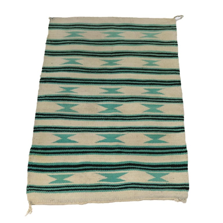 Southwest Native American 40"x23" Woven Wool Striped Throw Rug C1930: A finely crafted Southwest Native American woven wool throw rug from circa 1930. This piece features traditional striped patterns with geometric designs in shades of green and black against a cream ba