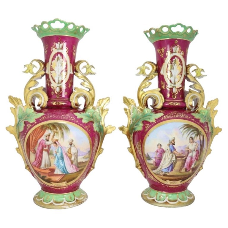 Old Paris Porcelain Scenic Vases - Crowning of Esther & Marriage of Isaac, C1890: This pair of antique Old Paris porcelain vases, dating to approximately 1890, features elaborate hand-painted scenic panels and extensive gilt decoration. Each vase is adorned with a rich magenta grou