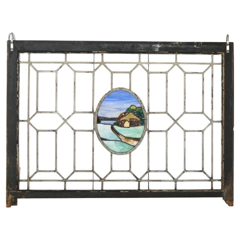 Arts & Crafts Leaded & Stained Glass Window With Country Road C1910: A fine example of Arts & Crafts design, this leaded and stained glass window features a central oval medallion depicting a serene country road scene. The surrounding geometric pattern is typical of th