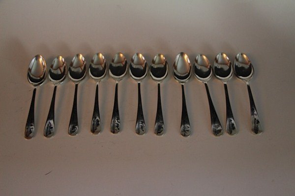 SET OF ELEVEN IRAQI DESSERT SPOONS: FULLY ENGRAVED WITH ARABIAN SCENE PROBABLY 850-900 SILVER CONTENT 341G 6.5" L