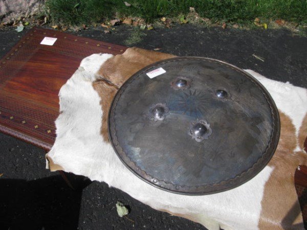 ANTIQUE MILITARY METAL SHIELD FROM RAJASTHAN INDIA: GIFT FROM THE LAST MAHARAJAH OF KOTAH, RAJASTHAN, INDIA INSCRIBED WITH CENTRAL MOTIF OF THE SUN 18"D