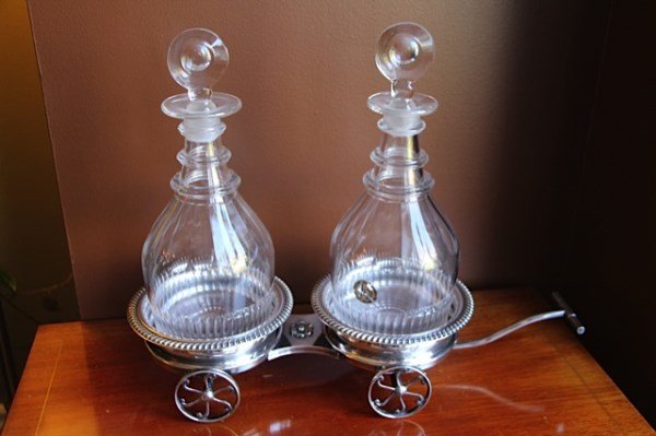 ANTIQUE COOLER WAGON WITH GEORGIAN DECANTERS: DOUBLE COOLER DRINKS WAGON RAISED ON FOUR WHEELS WITH CRYSTAL DECANTERS COMPLETE WITH STOPPERS AND STICKER MARKED "THE BRITISH ANTIQUE DEALERS ASSOCIATION LTD." 16" L X 13" H