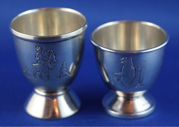 TWO ANTIQUE CHILDRENS 830S NORWEGIAN EGGCUPS: ONE BY NILS HANSEN, WITH CHILD RIDING A GOAT, SECOND WITH UNDETERMINED MAKERS MARK BOTH 2" H