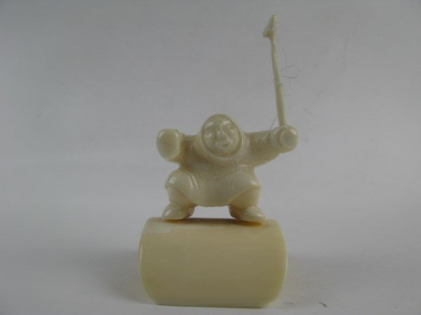CREAMY WHITE INUIT/ESKIMO CARVING OF A HUNTER: UNKNOWN ARTIST, THE DELICATELY CARVED HUNTER IS HOLDING A RAISED SPEAR AND IS MOUNTED ON A CURVED PEDESTAL MARKED 4.25 P TO BASE 3.5" H X 2.5" W X 2.5 " D