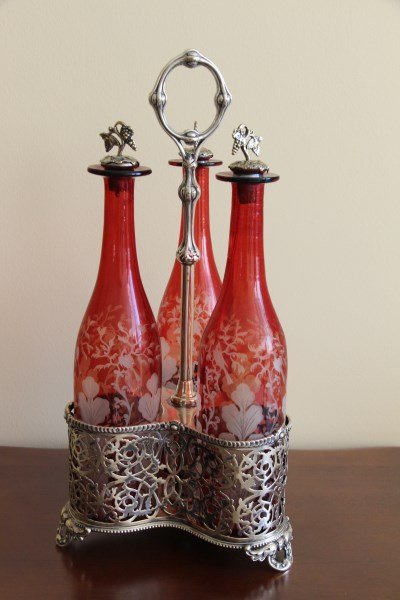 BAVARIAN CONDIMENT/DECANTER SET: THREE CRANBERRY DECANTERS WITHIN A SILVER HOLDER 17.5" H