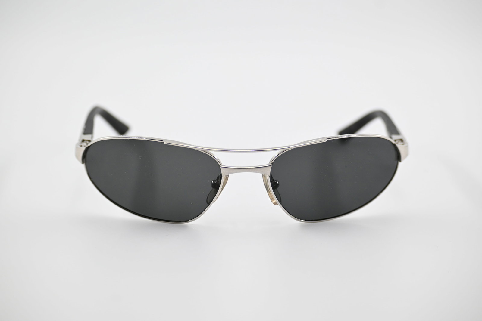Cartier Paris Silver-Tone Oval Aviator Sunglasses Made in France: Authentic Cartier Paris sunglasses featuring a sleek silver-tone metal frame with double-bridge aviator design and black composite temples with signature Cartier screw accents. Key Features: Marked "C
