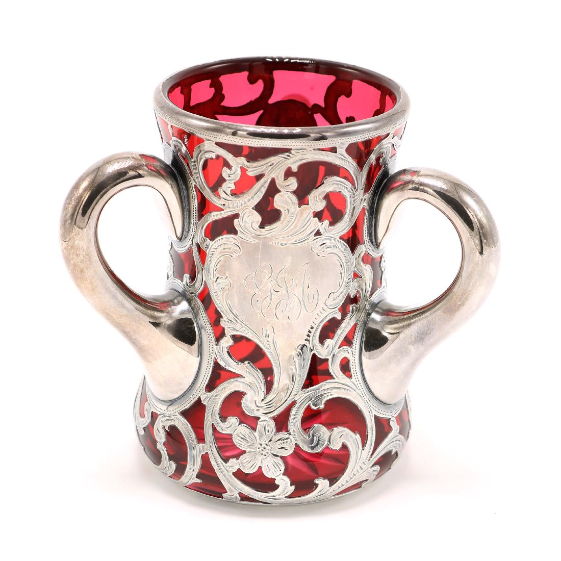 Red 999 Silver Overlay Loving Cup: Red glass cup with 999 silver floral motif overlay. Shows some scratching on glass (mostly on the base) and some wear on the silver, but is in overall good condition consistent with age. Please see ph