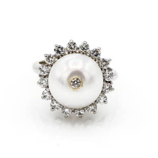 14K White Gold Diamond and Pearl Ring: 14k white gold ring featuring a 12mm pearl surrounded by a row of diamonds as well as 1 bezel set diamond in the center of the pearl. Diamonds weigh approx 0.95ctw. The ring is 18mm wide, a size 7,