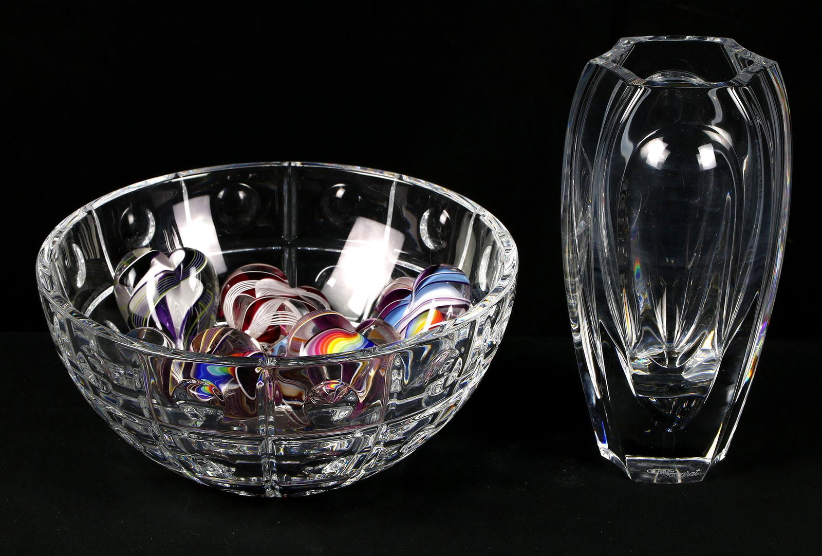 Baccarat Crystal Vase and Bowl: Lot consists of a Baccarat crystal bowl and vase. The vase shows a small chip on the lip and well as a few fleabites. Both pieces show minor shelf wear on the bases. Little heart glass paperweights fo