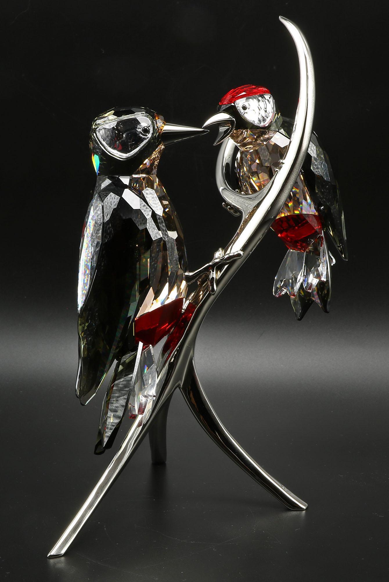 Swarovski Paradise Woodpeckers 957562: Swarovski Paradise Woodpeckers item number 957562. Includes Swarovski box. Measures approx 9" t. Texture reflected onto the crystal is from the photo box. Have a similar item to sell? Contact us a