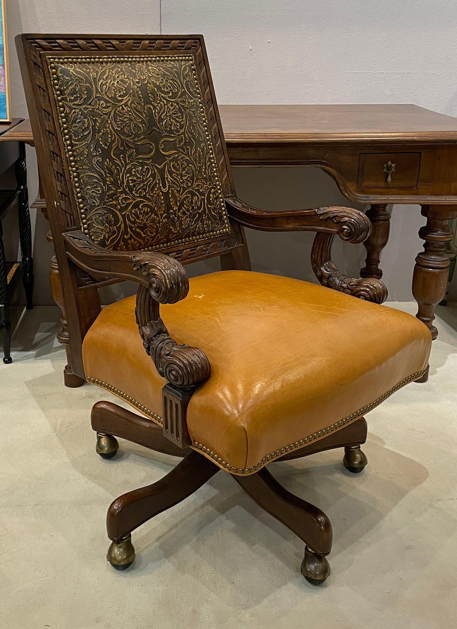 Robb & Stucky Upholstered Leather Executive Desk Chair: Upholstered leather executive desk chair by Robb & Stucky. Features carved arms, back frame, and base. Studded trim around the cushions. Leather and wood finish both show some wear. Measures appro