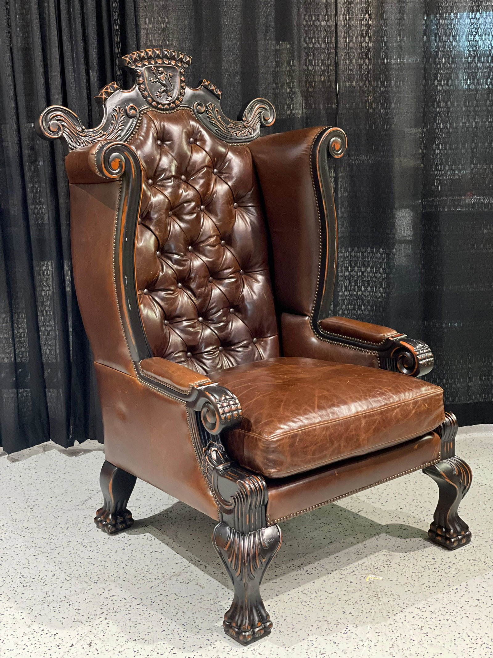 Large Furniture Your Way Leather Wingback Armchair: Large Leather wing back arm chair by Furniture Your Way. Features a tufted back along with carved scrollwork. Wood shows a blemish here and there. The leather shows some scratching and wear to the fin