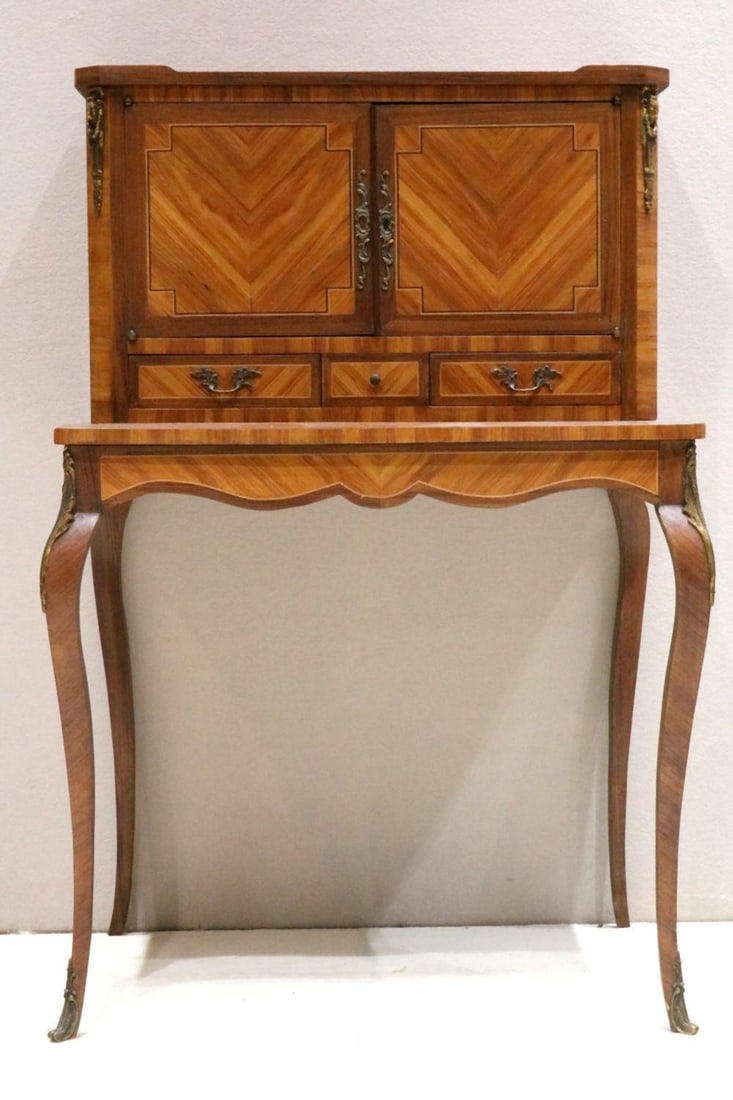 Antique French Louis XV Style Writing Desk: Antique French Louis XV Style Writing Desk, boasting 2 swinging cabinet doors over 2 drawers. Features brass/gilt sheep's head ornamentation on the top corners of the cabinet portion, which run pa