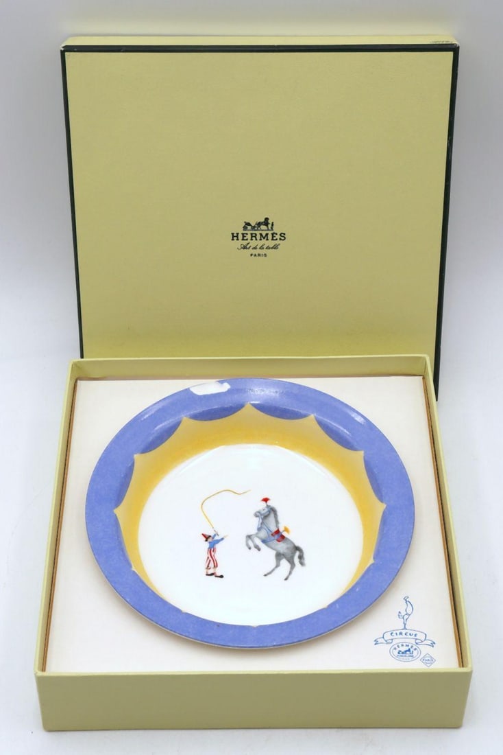 As is, Hermes "Circus" Porcelain Bowl with Box: As is, Hermes "Circus", "Le Clown Au Fouet" Porcelain Children's Bowl with Box. Bowl is chipped. Depicting a hand-painted illustration of circus tamer and horse. Measures approx. 6