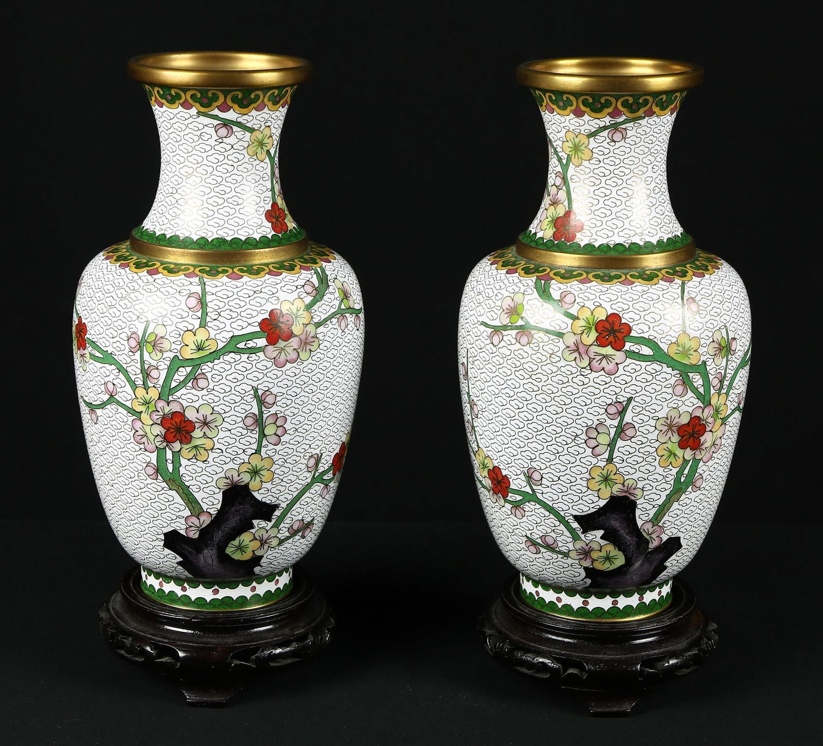 Pair of Cloisonne Vases: A pair of Cloisonne vases on carved wooden bases. The vases are in great condition. They do not show any visible chips or repairs. They measure approx 9" tall (without base) x 4.75" w. Have a