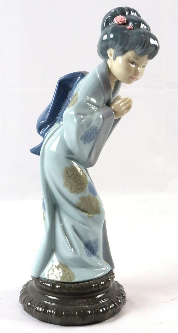 Lladro "Sayonara" #4989 Porcelain Figurine: Lladro "Sayonara" #4989 Porcelain Figurine. Measures approx. - 10 1/2" H x 3" W x 4" D. Stamped" Lladro 4989" underneath base. Condition is overall good. Have a similar ite
