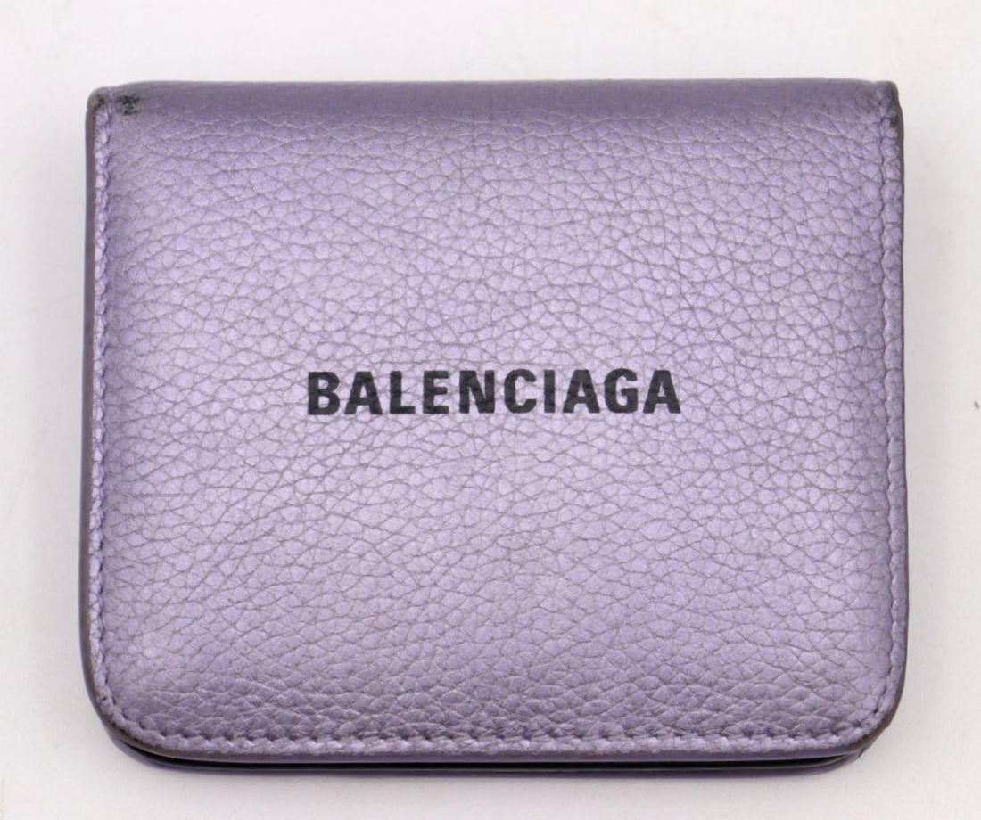 Balenciaga Mini Metallic Purple Wallet & Gold Tone Chain: BALENCIAGA MINI METALLIC PURPLE WALLET WITH GOLD-TONE CHAIN, SPAIN A striking compact accessory, this mini metallic purple wallet by Balenciaga features a vibrant, high-shine finish complemented by a