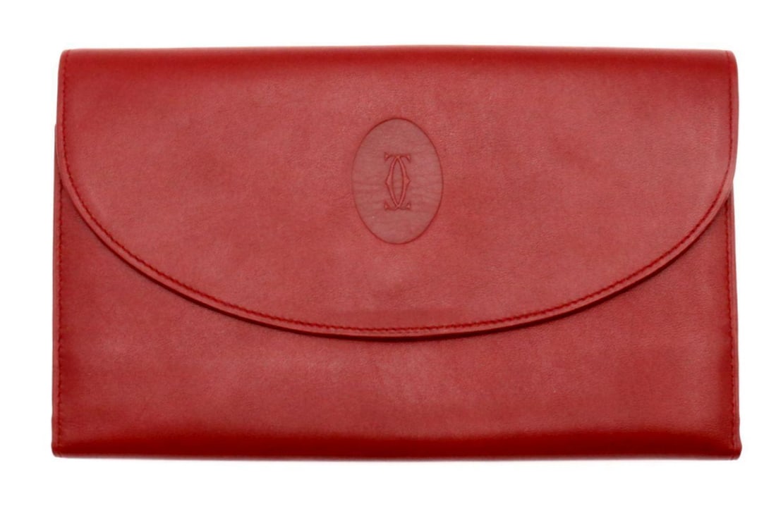 Cartier "Must de Cartier" Burgundy Leather Clutch: Cartier, French. “Must de Cartier” Burgundy Leather Clutch. Rendered in richly hued burgundy leather, this refined clutch exemplifies the timeless elegance of Cartier’s “Must d
