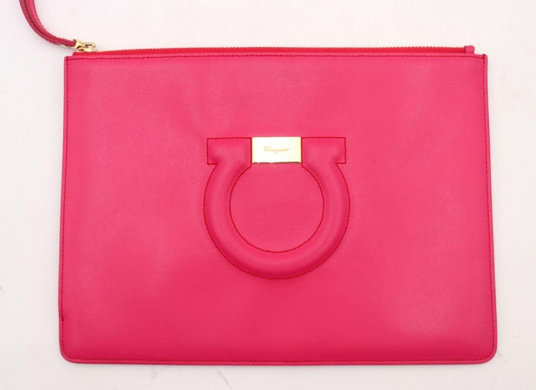 Salvatore Ferragamo Pink Leather Gancini Zip Pouch: SALVATORE FERRAGAMO Pink Leather Gancini Zip Pouch Crafted in smooth pink leather, this refined zip pouch features Ferragamo’s iconic Gancini emblem in polished metal, lending a touch of signatu