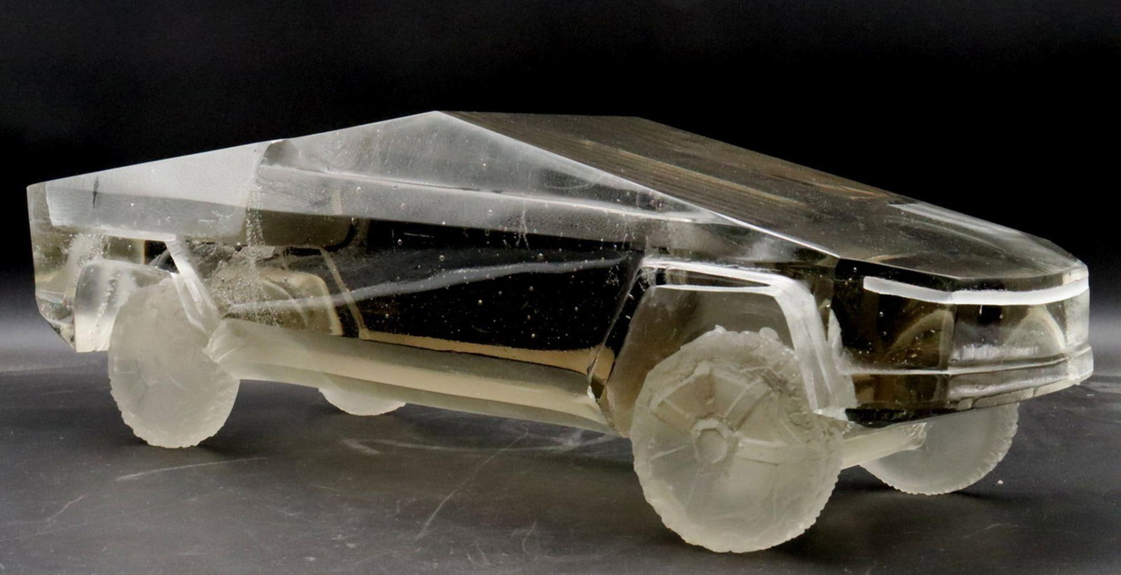 Kristian Mankos "Glass Cybertruck" Sculpture: Kristian Mankos (American, b. 1977) Glass Cybertruck Sculpture 6.3" H x 19.7" W x 7.5" D A handcrafted glass sculpture depicting a pickup truck, emphasizing geometric form and transparency