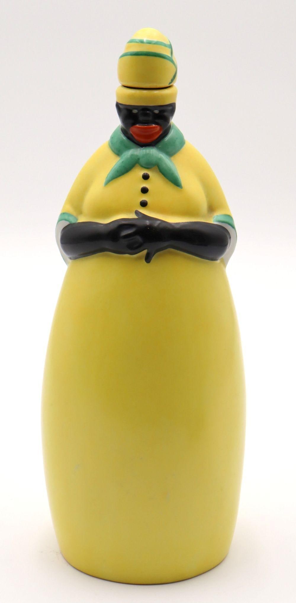 Rare Robj Art Deco Porcelain Decanter: Robj Paris (French) “Mammy” Art Deco Porcelain Decanter Art Deco period 10 3/8" H x 4 1/8" W A porcelain figural decanter in the form of a “Mammy” figure, executed in t