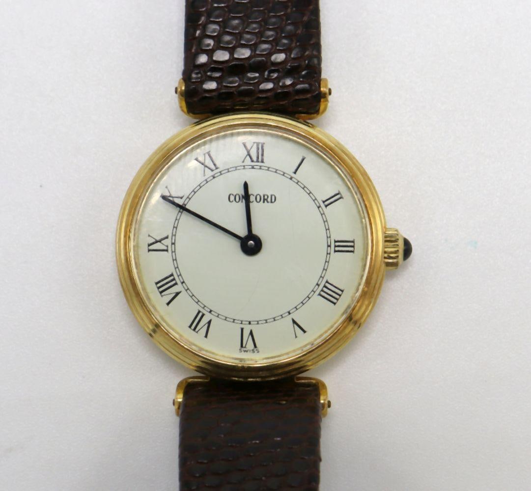Vintage Concord 14Kt Yellow Gold Ladies Watch: Concord 14Kt Yellow Gold Ladies Wristwatch Mid-20th Century. A vintage Concord ladies wristwatch crafted in 14 karat yellow gold, fitted with a lizard leather band (non-original to the watch). Conditi