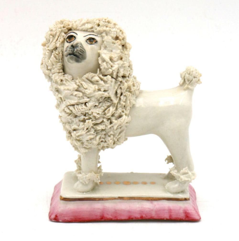 Early 20th C. Staffordshire Porcelain Poodle Figurine: Staffordshire Porcelain Poodle Figurine English Early 20th Century 3" H x 3" W x 1" D A hand-painted porcelain figurine depicting a seated poodle, modeled with textured fur and expressive 