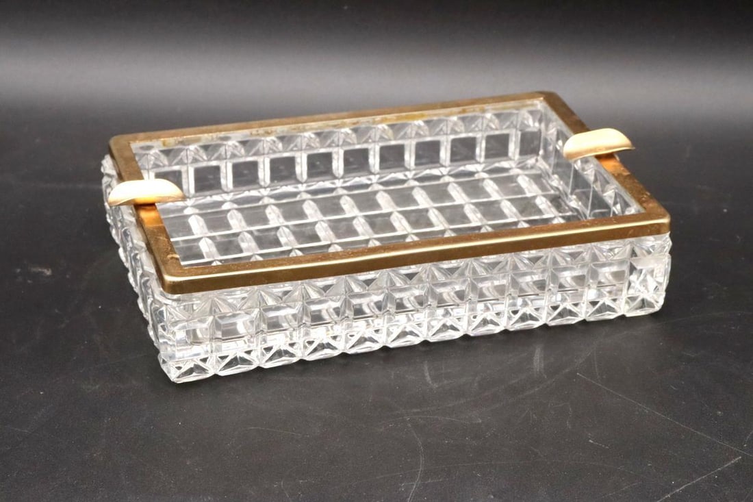 20th C. Cut Crystal and Gold-Plated Ashtray: Unmarked Ashtray Cut crystal and gold-plated metal, unmarked 1.75" H x 7.75" W x 4.75" D Condition: Good condition with light wear to the gold plate. Have a similar item to sell? Contact