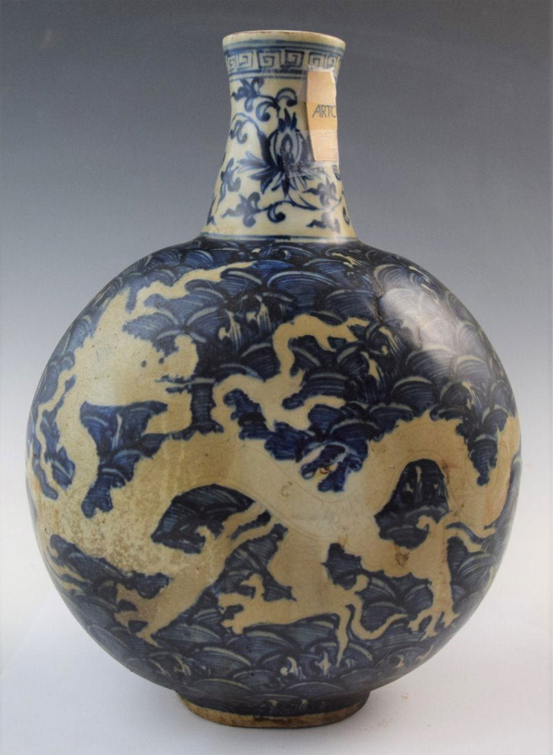 Chinese Blue and White Dragon Flask (Artcurial label): Chinese Blue and white porcelain dragon motif flask. The exterior painted in blue with a dragon and crashing waves. Wide body design, a short neck with a floral pattern and an Artcurial auction label