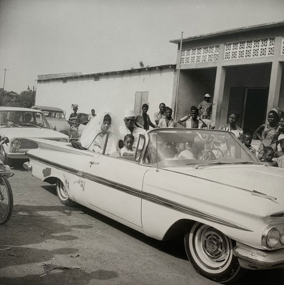 Malick Sidibe (Arrival of the Wedding Car) Photo-Litho: MALICK SIDIBE (1935-2016) Arrival of the wedding car in front Photo litho Printed circa fourth quarter 20th c. 7 1/4" x 7 1/4"