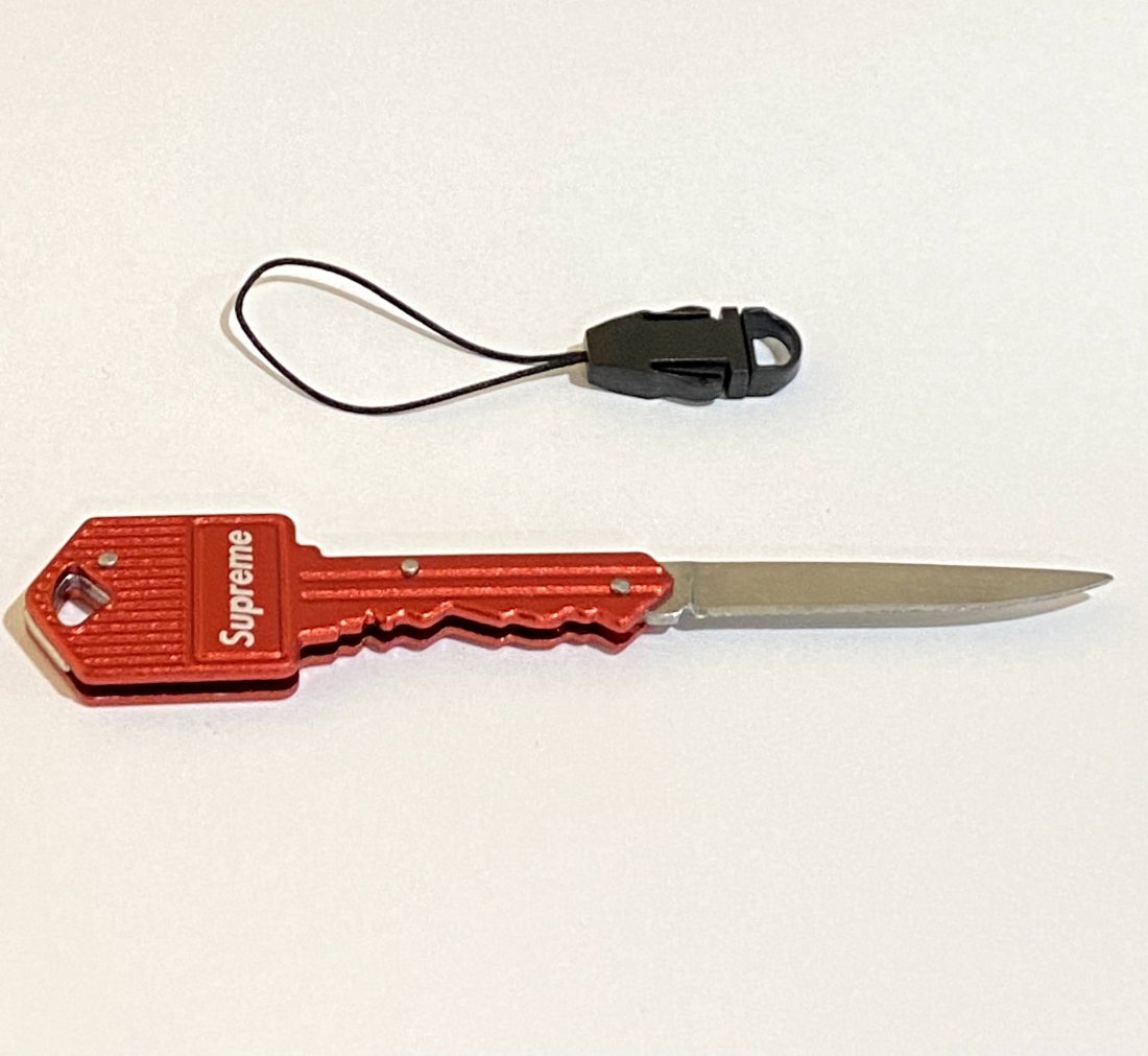Supreme pocket knife: Red with white Supreme issued pocket knife.
