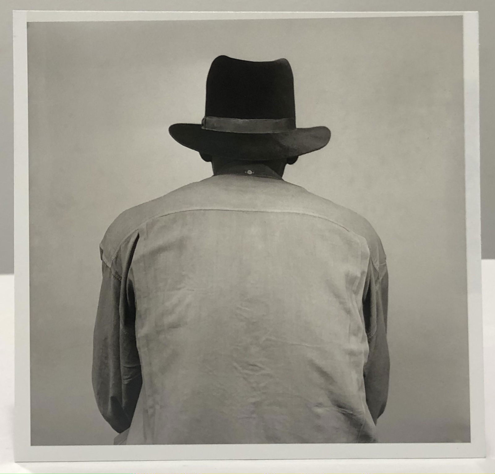 Malick Sidibe (Untitled) Glossy Photo-Litho: MALICK SIDIBE (1935-2016) Untitled (Seated Man) Glossy photo-litho Printed circa later 20th c. 7 1/2" x 7 1/2" Mounted to same sized cardstock