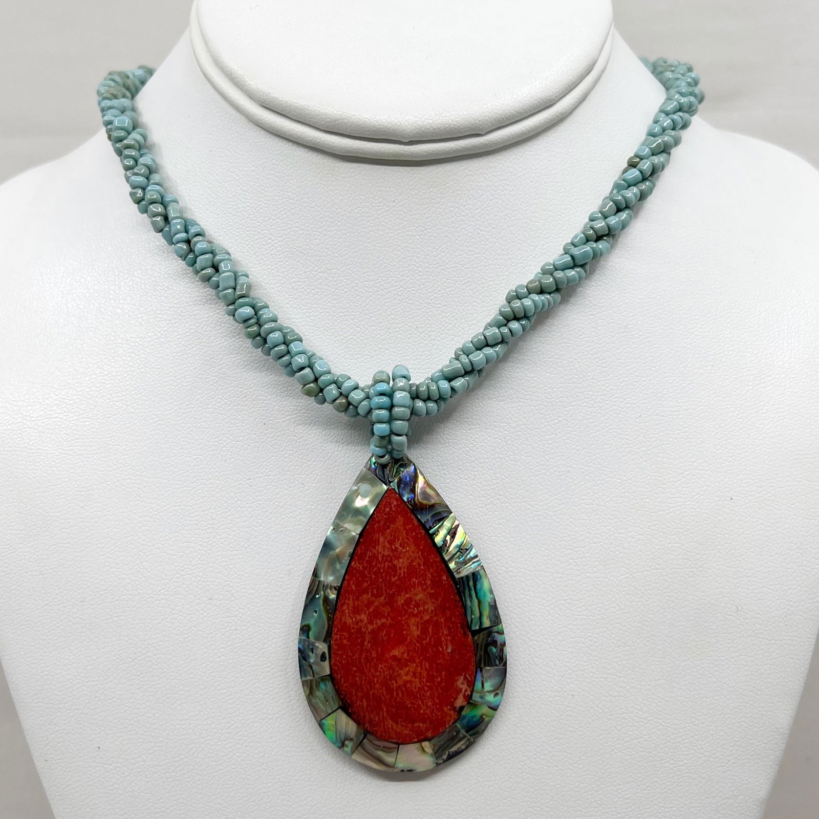 coral abalone & turquoise seed bead necklace: Measures: 18" long Pendant: 2 3/4" long Crafted with coral & abalone inlay & turquoise glass seed beads In good pre-owned condition