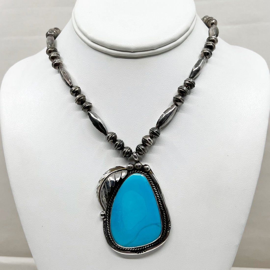 Steven Apachito Navajo sterling silver turquoise necklace: Chain: 17 3/4" long Pendant: 2 3/8" long by 1 5/8" wide Crafted with 44x32mm turquoise & 8mm to 20x7mm sterling pearl beads Signed: SA In good pre-owned condition
