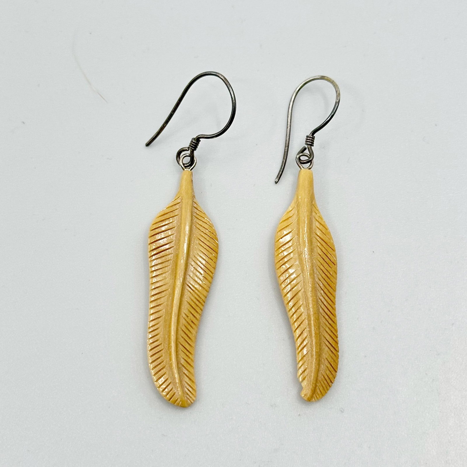 Alaska Sterling silver carved feathers walrus ivory earrings: Measures: 2 1/8" long Crafted with 37x10mm carved feathers walrus ivory Weights: 2 grams Condition: like new SKU-1234