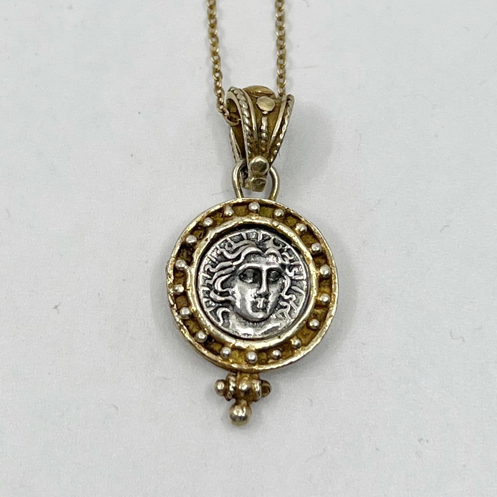Gold vermeil sterling silver drachma Greek coin necklace: Chain: 18" long Pendant: 1 3/4" long by 5/8" wide The drachm silver coin its a reproduction Material: sterling silver Condition: Like New SKU-1462