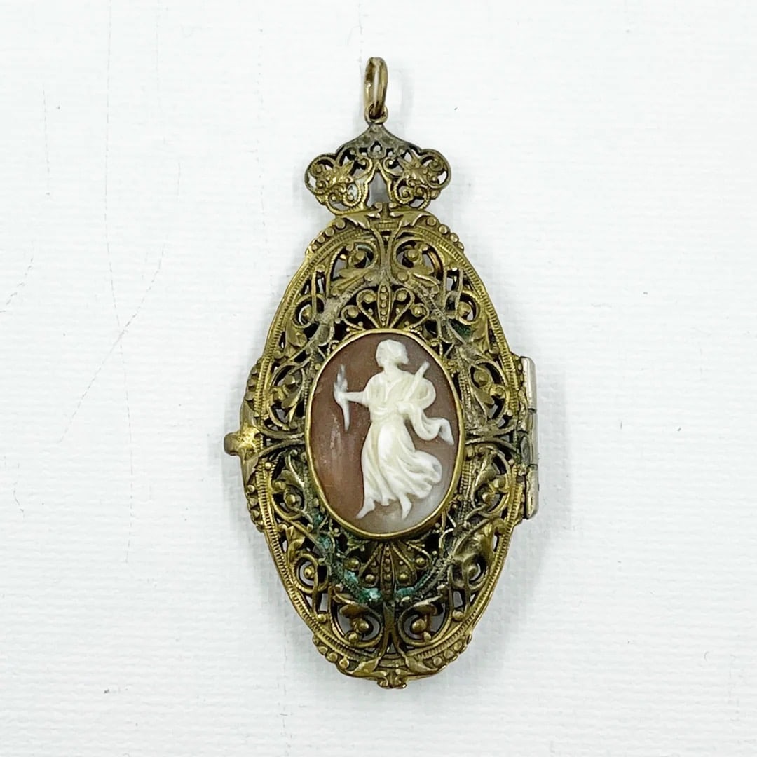 Art Nouveau brass shell cameo locket pendant: Measurements: 2 1/2” long by 1 1/4” wide gemstone: 20x15mm shell cameo metal: brass condition: good SKU-1778