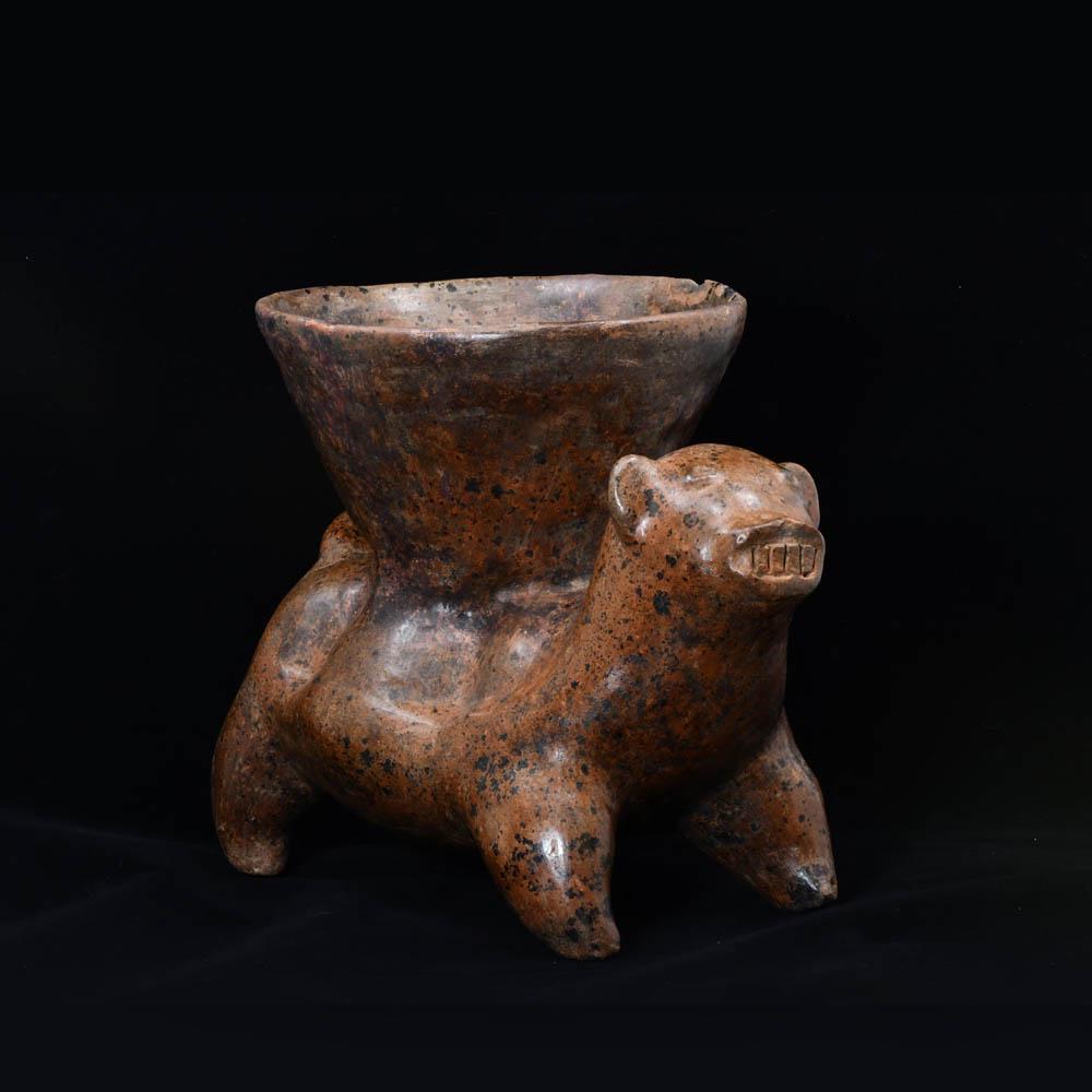 A Colima Redware Dog with Bowl, ca. 100 BCE/CE: A Colima Redware Dog with Bowl, ca. 100 BCE/CE, ca. 100 BCE/CE: Medium: Ceramic of dark burnished redware, the dog standing on four short legs, facing forward with ears up and teeth bared, a large con