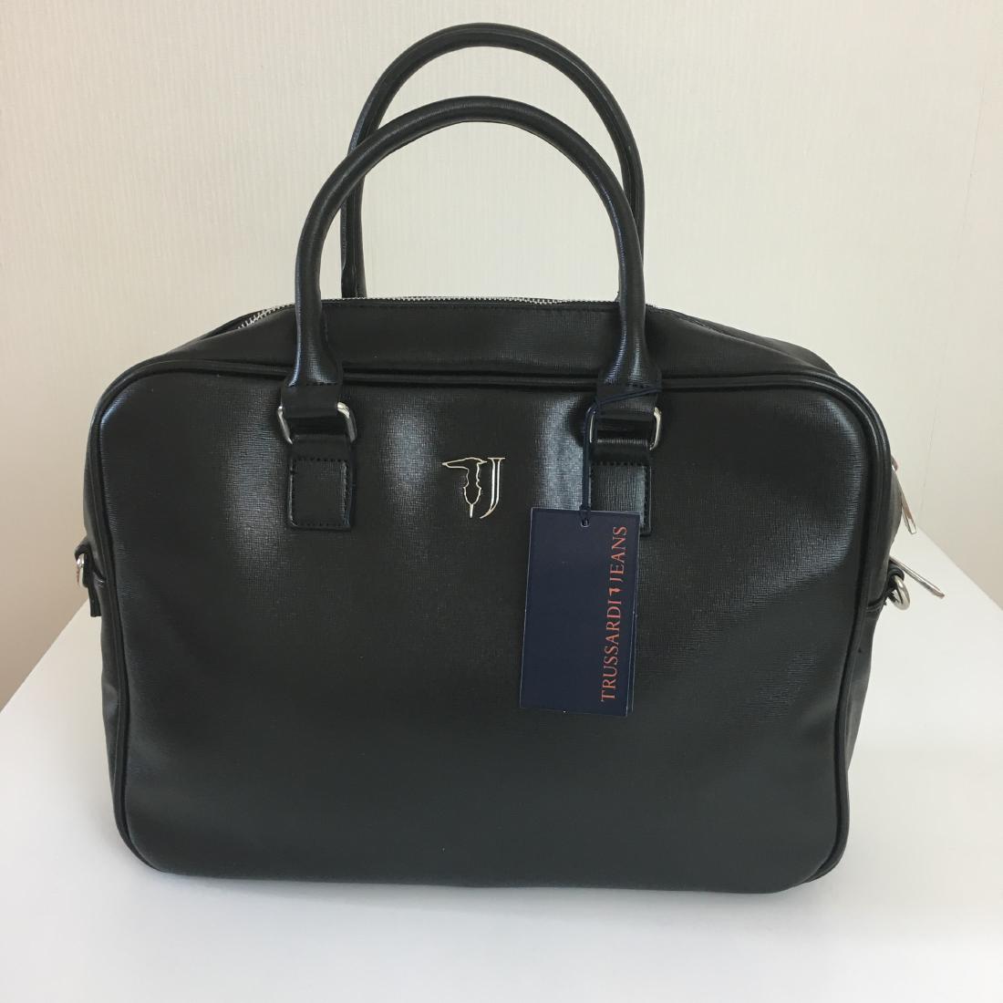 Trussardi Black Eco Leather Briefcase Laptop Bag: Eco Leather. Adjustable and removable nylon stra. Internal organization with padded laptop compartment and multiple pockets. Fully lined with washable and branded fabric. Metal external zip, branded z