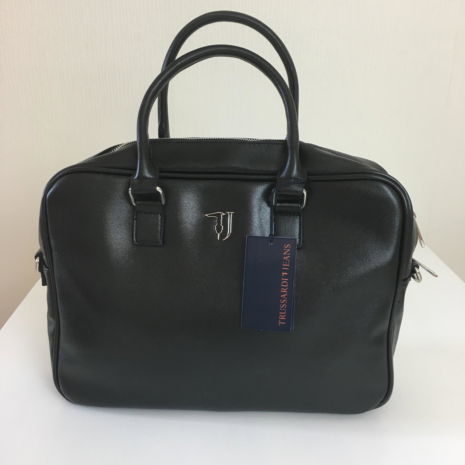 Trussardi Black Eco Leather Briefcase Laptop Bag: Eco Leather. Adjustable and removable nylon stra. Internal organization with padded laptop compartment and multiple pockets. Fully lined with washable and branded fabric. Metal external zip, branded z