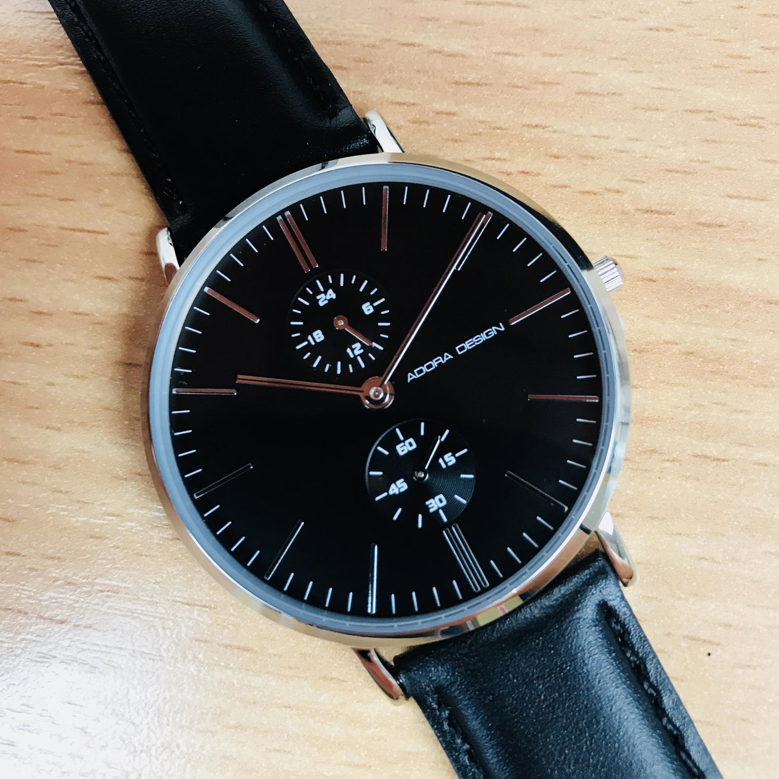 Adora Design Mens Modern Casual Black Watch: ï‚§ Stainless steel case, silver colored coating, polished.ï‚§ Leather strap, black, pin buckle.ï‚§ Mineral glass.ï‚§ Seiko quartz movement, battery operated.ï‚§ Small second, 24 h