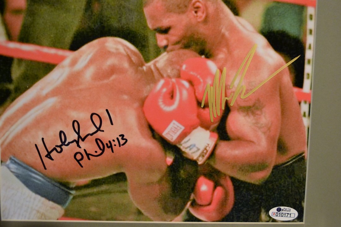 Mike Tyson and Evander Holyfield Sign Photo Bite Ear: very nice hand sign photo by Mike Tyson and Holyfield, given to us by the Ring girl sign for her....they don't like to sign this picture anymoreNote... any flash you see is not on the photo but in cam