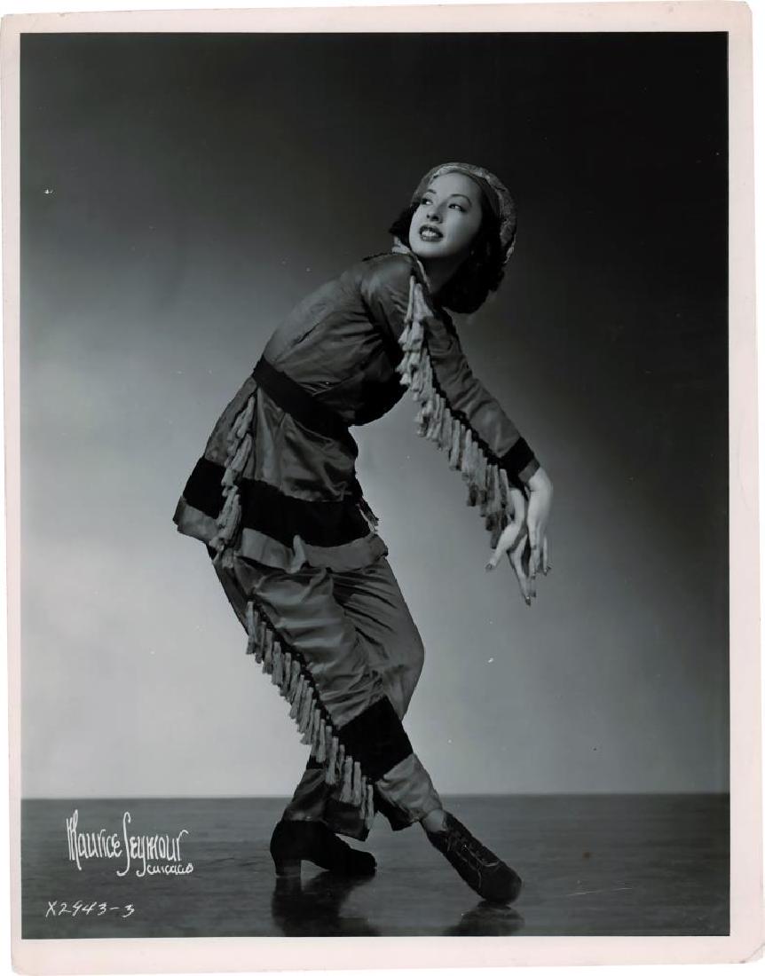 BALLETS RUSSES, BASIL, SONO OSATO: 2 photographs of Sono Osato. Stamp of the Ballets Russes of Colonel W. de Basil. 15,8 x 20,2 cm. 23,7 x 18 cm. In excellent condition.