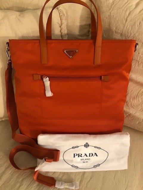 Prada B2530T Tessuto Nylon Convertible Tote Bag: Pack up and go almost anywhere with this classic carryall from Prada. Crafted in tessuto nylon that's durable & lightweight, stow all your essentials in this roomy tote. Shopping Bag. Color: Papaya NE