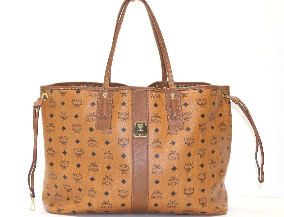 MCM Reversible Shopper: Brand: MCM Model: Large Liz Reversible Shopper Color: Cognac Style:Y8952 Description: Coated canvas with leather trim Double handles Clasp closure; lined 13"W x 7"D x 17"H; 8.5" handle drop Coated can