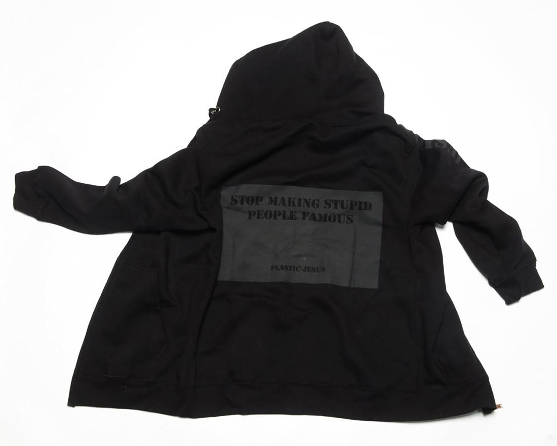 PLASTIC JESUS 'Stop Making Stupid People Famous' Full: 'Stop Making Stupid People Famous' by Plastic Jesus, 2020 Premium full zip hoodie (black). Soft cotton blend with subtle black on black graphic on reverse, artist graphic on sleeve. Size: Men's XXL Cu