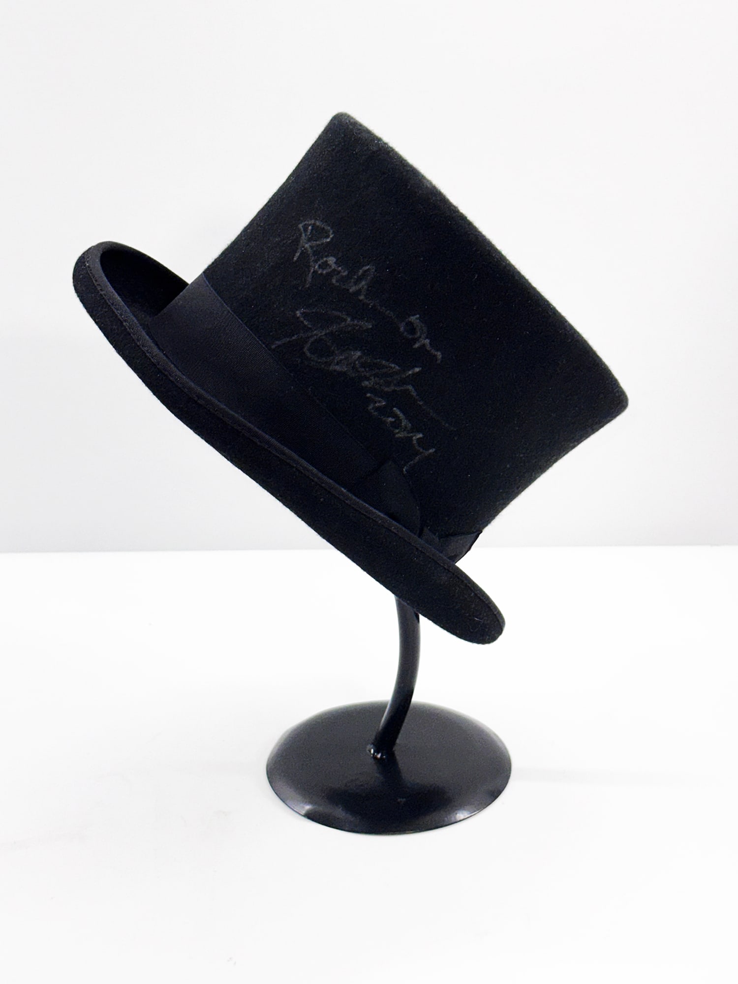 GUNS N' ROSES 'Slash' (2014) Hand-Signed + Dated Top Hat w/Stand: SLASH from Guns N' Roses, 2014 Approx. 11 x 12.5 x 6.5 Inches (hat) 15 x 6 x 6 Inches (stand) 100% Wool top hat by JHats. Size: 62 Centimeters; RN#: 62187 Hand-signed "Rock On, SLASH, 2014" in silver