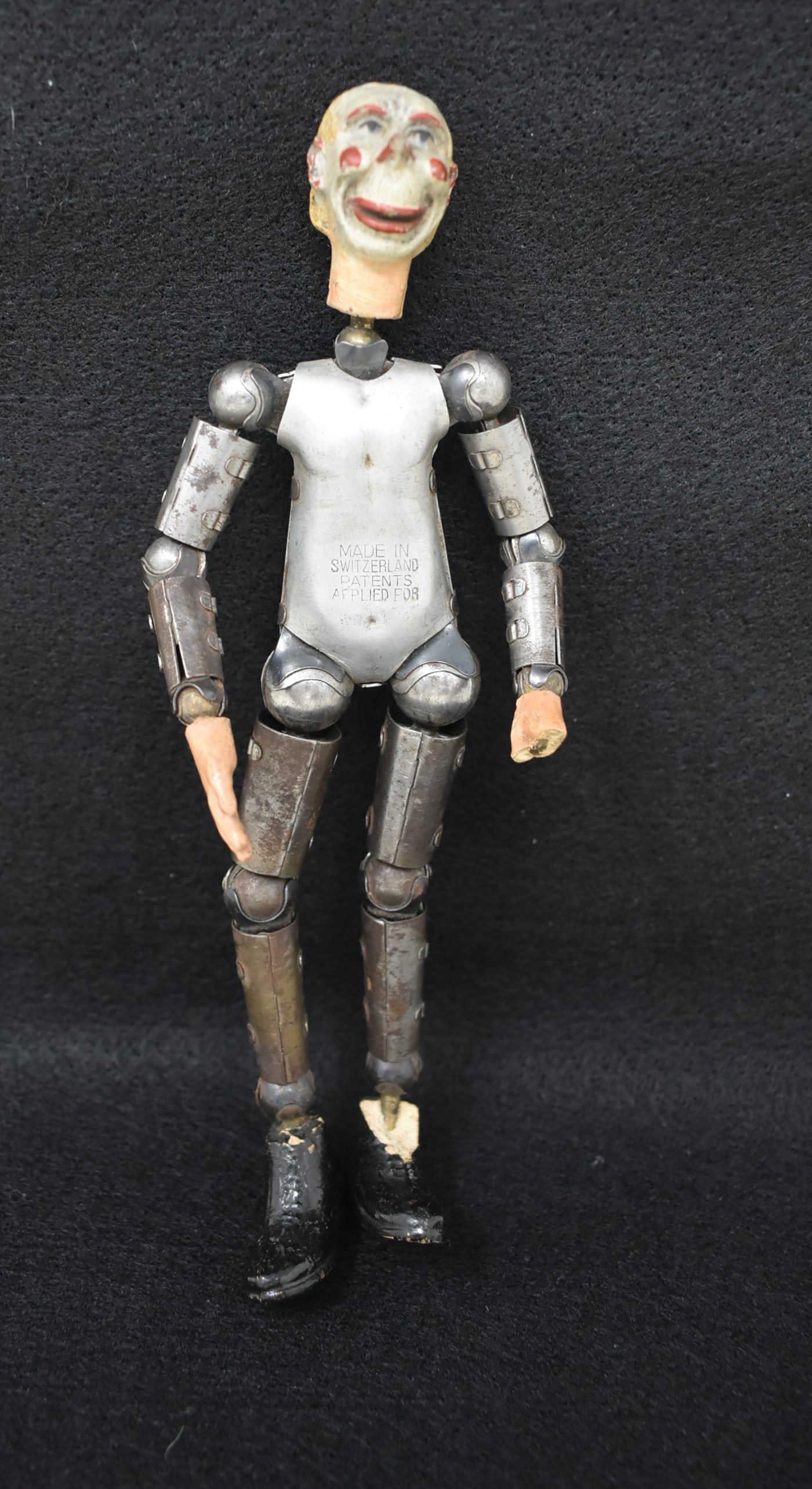 1920s Swiss Saba Bucherer Metal Jointed Doll: 1920s Swiss Saba Bucherer Metal Jointed Doll with Clown Face, 7.5". One had is broken and one boot is damaged.